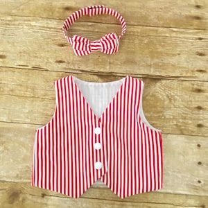 Puede incluir: Un chaleco a rayas rojas y blancas con botones blancos. También se incluye una diadema a juego con un lazo de pajarita a rayas rojas y blancas.