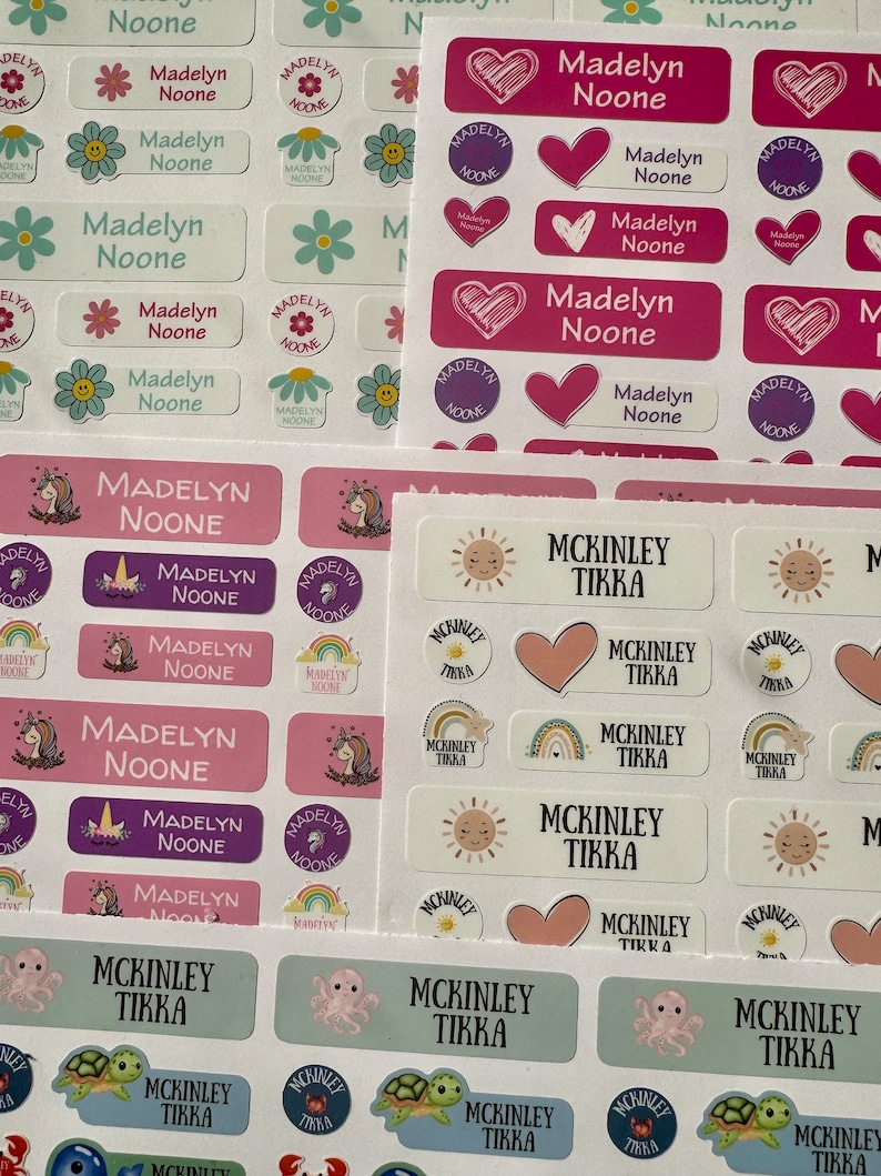 Pu&ograve; includere: Un set di etichette per nomi personalizzate colorate con vari design. Le etichette presentano i nomi "Madelyn Noone" e "McKinley Tikka" in diversi caratteri e colori. Alcune etichette hanno un design a forma di cuore, sole, unicorno, arcobaleno, polpo e tartaruga.