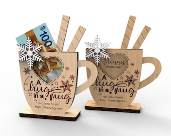 Könnte beinhalten: Zwei Holz-Geschenkehalter "A hug in a mug". Einer enthält eine Geschenkkarte und Holzrührstäbchen. Der andere hat "Merry Christmas!" und Holzrührstäbchen. Beide haben Schneeflocken- und Sternakzente und sind personalisiert.