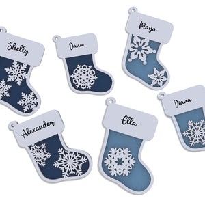 Puede incluir: Seis adornos de calcetines navideños azules y blancos con diseños de copos de nieve y nombres personalizados: Shelly, Dana, Maya, Diana, Ella y Alexander.