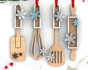 May include: Four wooden kitchen utensil ornaments with snowflake designs. The ornaments are a spatula, whisk, spoon, and rolling pin.