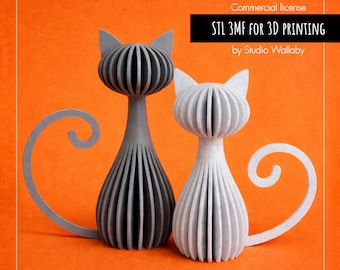 Puede incluir: Dos esculturas de gatos estilizados, una gris y otra blanca, con cuerpo y cabeza acanalados, y colas enroscadas. El fondo es naranja. El texto dice "STL 3MF FOR 3D PRINTING by Studio Wallaby."