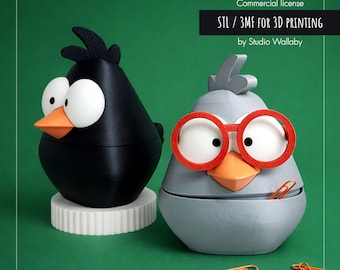 May include: Two 3D-printed bird-shaped containers, one black and one gray, with orange beaks and large white eyes. The gray bird wears red glasses. The containers are on a green background. Text reads "Commercial license STL / 3MF FOR 3D PRINTING by Studio Wallaby."