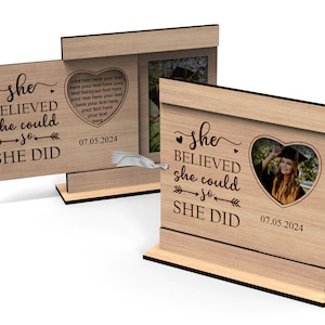 May include: A wooden picture frame with a heart-shaped cutout for a photo. The frame has the text "She believed she could so she did" and the date "07.05.2024".