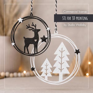 May include: Two circular hanging ornaments with black and white string. One black ornament features a deer with a heart cutout and stars. One white ornament features two pine trees and stars. Text reads: Commercial license STL FOR 3D PRINTING by Studio Wallaby.
