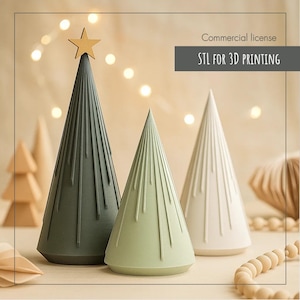 May include: Three decorative Christmas trees in shades of green and white, with a gold star on top of the darkest green tree. The trees have a conical shape with vertical lines. The text "STL FOR 3D PRINTING" is visible.