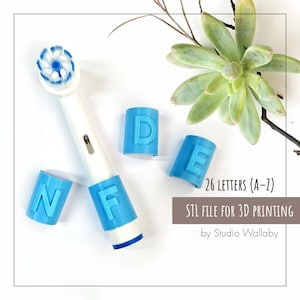 May include: An electric toothbrush head with blue lettered caps spelling "NFE" and "D E". The image includes the text "26 LETTERS (A-Z) STL FILE FOR 3D PRINTING". A succulent plant is in the background.