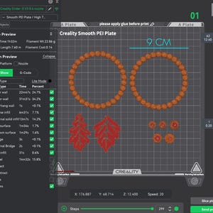 May include: A digital 3D printer interface showing a Creality Smooth PEI Plate with a G-code preview. The screen displays two orange circular wreaths, two red leaf shapes, and four small orange circular accents, with a 9 cm measurement indicator.