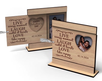 May include: A wooden photo frame with a heart-shaped cutout for a photo. The frame has a quote that reads "Live every moment, Laugh until it hurts, Love like crazy." The date "02.14.2024" is also engraved on the frame.