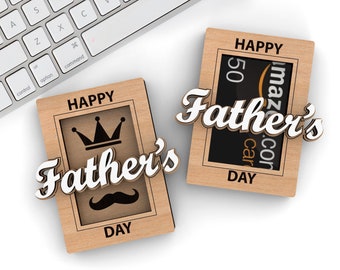 Może przedstawiać: Dwa drewniane pudełka prezentowe z napisem "Happy Father's Day". Jedno pudełko zawiera koronę i wąsy, drugie zawiera kartę podarunkową Amazon o wartości 50 €.