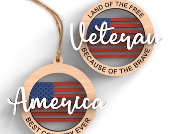May include: Two wooden ornaments with American flag designs. The first ornament says "Land of the Free, Veteran, Because of the Brave". The second ornament says "America, Best Country Ever".