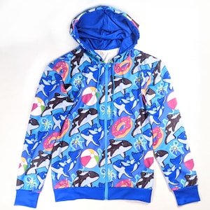 May include: A blue zip-up hoodie with a colorful all-over print featuring orcas, donuts, and beach balls.