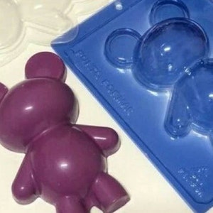 May include: A purple silicone mold of a teddy bear with a blue silicone mold of a teddy bear in the background.