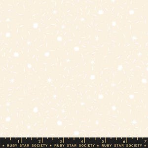 May include: Cream-colored fabric with a repeating pattern of white starbursts, dashes, and dots. The fabric has a soft, textured appearance, suitable for quilting or other craft projects. The bottom of the image has a ruler with the text "RUBY STAR SOCIETY".