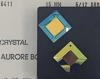 Puede incluir: Dos cristales de imitación cuadrados con un agujero en la parte superior. El cristal de imitación más grande es azul con un centro amarillo y mide 16 mm. El cristal de imitación más pequeño es verde con un centro marrón. El texto "6/12 GRO" es visible en la imagen.