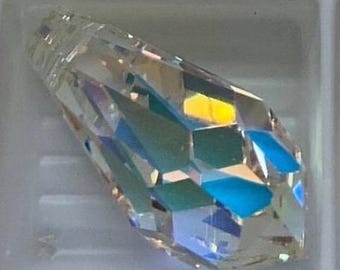 May include: A clear crystal prism with a faceted design. The prism reflects light in a rainbow of colors.