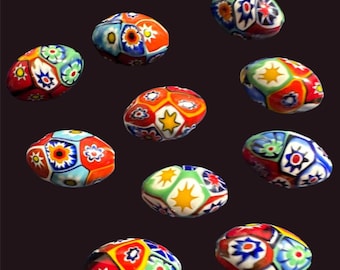 May include: Assortment of colorful, oval-shaped glass beads with intricate geometric patterns. The beads feature a mix of red, blue, green, yellow, and white colors.