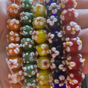 Q30, 12 mm Lampwork flower beads including orange, red, yellow, deep blue, and green