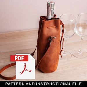 May include: A brown leather wine bottle carrier with a drawstring closure and a shoulder strap. The carrier is holding a bottle of wine and there are two wine glasses on the table next to it. The text "PDF" and a PDF icon are visible in the lower left corner of the image. The text "PATTERN AND INSTRUCTIONAL FILE" is visible at the bottom of the image.
