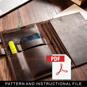 以下が含まれることがあります： 複数のポケットとジッパー付きの茶色の革製ノートブック。ノートブックが開かれており、中に携帯電話と蛍光ペンが見えます。画像に「PDF」というテキストが表示されています。