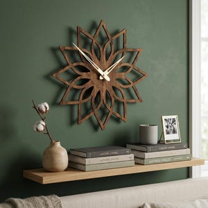 Puede incluir: Un reloj de pared de madera marrón oscuro con un diseño geométrico recortado en forma de estrella y manecillas de metal fino de color dorado. El reloj presenta un centro circular y segmentos puntiagudos en forma de pétalos que irradian.