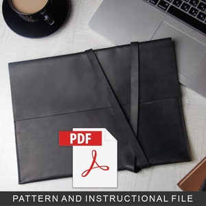 Puede incluir: Una funda para portátil de cuero negro con solapa y cierre de correa. La funda está sobre una superficie blanca con un portátil, una taza de café y un cuaderno. El texto "PDF" está impreso en rojo sobre fondo blanco con un logotipo de Adobe Acrobat rojo.
