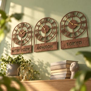 May include: Three arched wall clocks made of dark wood with Roman numerals and gold-colored hands. Each clock features a city name cut out at the bottom: New York, London, and Tokyo. The clocks are mounted side by side on a light green wall.