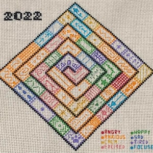 May include: A colorful cross-stitch pattern in the shape of a diamond with the year 2022 at the top. The pattern is made up of different colored squares and lines. The words "Angry", "Anxious", "Calm", "Excited", "Happy", "Sad", "Tired", and "Focused" are written at the bottom of the image.