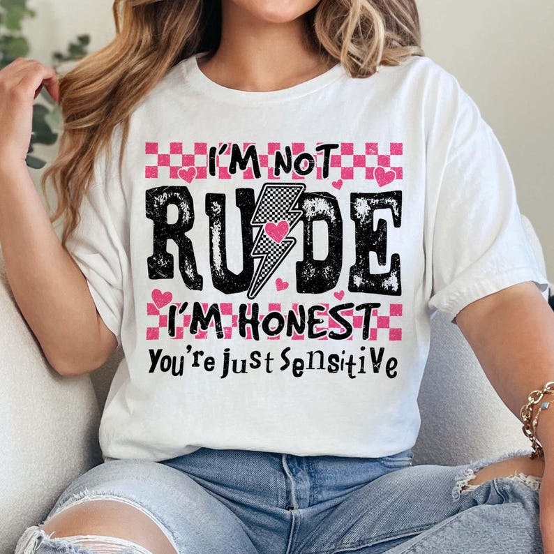 May include: White t-shirt with a pink and black graphic that says "I'm not rude I'm honest you're just sensitive".