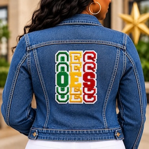 May include: A blue denim jacket featuring a large rectangular patch on the back. The patch displays three vertical columns of block letters in green, yellow, and red, spelling out the text O-C-O-O, E-E-E-E, and Q-S-S-Q in a stacked arrangement.
