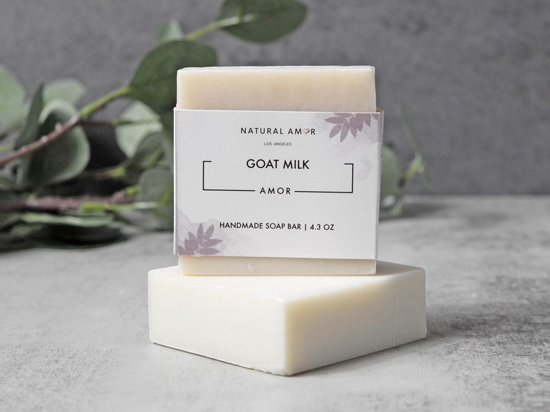 May include: A white bar of goat milk soap with a label that reads "Natural Amor Los Angeles Goat Milk Amor Handmade Soap Bar | 4.3 oz"