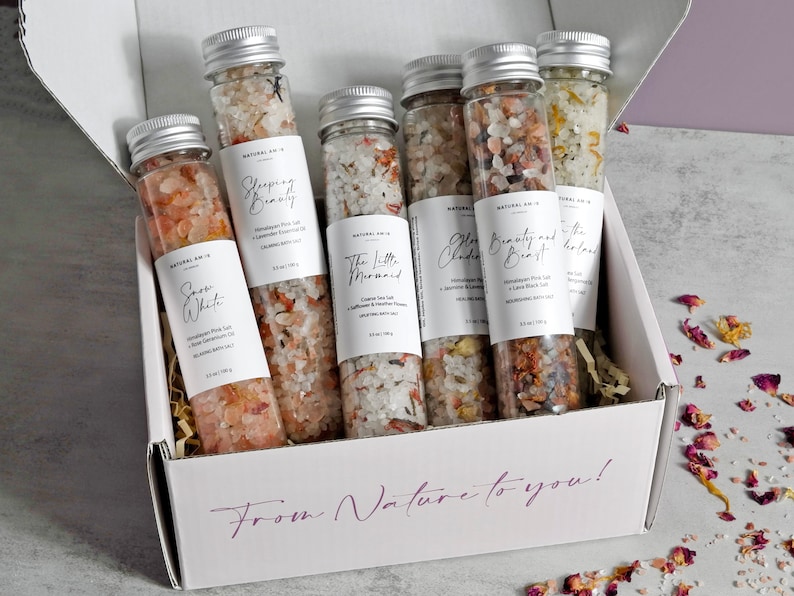 May include: A white box with the text "From Nature to you!" printed on the front. The box contains six glass tubes filled with bath salts. The tubes are labeled with different names, such as "Snow White", "Sleeping Beauty", and "The Little Mermaid".