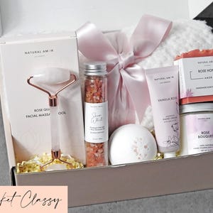 Puede incluir: Una caja de regalo que contiene una herramienta de masaje facial de cuarzo rosa, un tubo de cristal con sal de ba&ntilde;o rosa del Himalaya, una bomba de ba&ntilde;o blanca, crema de manos de vainilla y rosa, jab&oacute;n de miel y rosa, vela de soja y manta blanca.