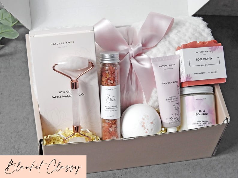 Puede incluir: Una caja de regalo que contiene una herramienta de masaje facial de cuarzo rosa, un tubo de cristal con sal de ba&ntilde;o rosa del Himalaya, una bomba de ba&ntilde;o blanca, crema de manos de vainilla y rosa, jab&oacute;n de miel y rosa, vela de soja y manta blanca.