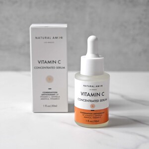 May include: A white bottle and box of Vitamin C Concentrated Serum by Natural Amor. The bottle has a white dropper and a clear liquid. The box and bottle both have the text "Vitamin C Concentrated Serum". The box and bottle also have the text "1 fl.oz | 30ml".