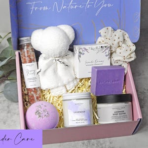 Puede incluir: Una caja de regalo con un oso de peluche blanco, un tubo de cristal con sales de ba&ntilde;o rosas, una pastilla de jab&oacute;n de lavanda, una vela de lavanda, un tarro de manteca corporal, una bomba de ba&ntilde;o morada y un coletero blanco con puntos dorados. La tapa dice From Nature to You.