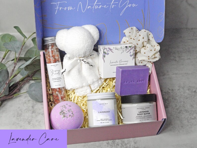 Puede incluir: Una caja de regalo con un oso de peluche blanco, un tubo de cristal con sales de ba&ntilde;o rosas, una pastilla de jab&oacute;n de lavanda, una vela de lavanda, un tarro de manteca corporal, una bomba de ba&ntilde;o morada y un coletero blanco con puntos dorados. La tapa dice From Nature to You.
