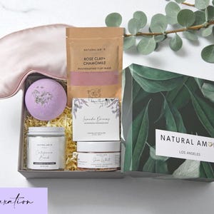 Puede incluir: Un set de regalo de Natural Amor Los Angeles que contiene un antifaz de seda rosa claro, una bomba de ba&ntilde;o morada, una bolsa de mascarilla Rose Clay + Chamomile, un jab&oacute;n Lavender Dreams, una vela California Beach y un exfoliante Snow White.