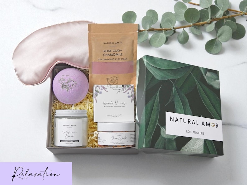 Puede incluir: Un set de regalo de Natural Amor Los Angeles que contiene un antifaz de seda rosa claro, una bomba de ba&ntilde;o morada, una bolsa de mascarilla Rose Clay + Chamomile, un jab&oacute;n Lavender Dreams, una vela California Beach y un exfoliante Snow White.
