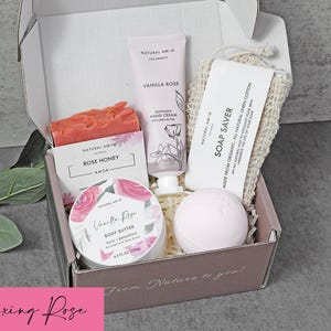 Puede incluir: Una caja de regalo que contiene una pastilla de jab&oacute;n Rose Honey, un tubo de crema de manos Vanilla Rose, un tarro de manteca corporal Vanilla Rose, una bomba de ba&ntilde;o rosa p&aacute;lido y una bolsa de lino para jab&oacute;n. La caja tiene el texto From Nature to you.