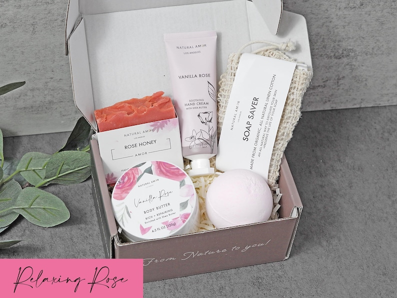 Puede incluir: Una caja de regalo que contiene una pastilla de jab&oacute;n Rose Honey, un tubo de crema de manos Vanilla Rose, un tarro de manteca corporal Vanilla Rose, una bomba de ba&ntilde;o rosa p&aacute;lido y una bolsa de lino para jab&oacute;n. La caja tiene el texto From Nature to you.