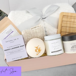 Puede incluir: Una caja de regalo que contiene una manta de felpa blanca con una cinta gris, una jabonera de bamb&uacute;, un jab&oacute;n de lavanda francesa Natural Amor, una bomba de ba&ntilde;o redonda, una vela de soja, manteca corporal y una mascarilla de arcilla.
