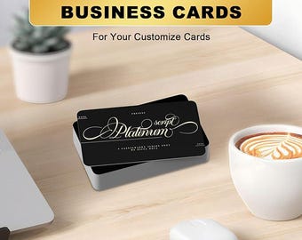 May include: A stack of black business cards with white script text that reads "Platinum" sits in a silver case. The text "CREATE IMPRESSIVE BUSINESS CARDS" is in a gold banner above the cards. A white coffee cup and wireless earbuds are also on the wooden surface.