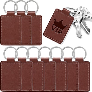 May include: A collection of brown leather keychains with silver key rings. One keychain has the word "VIP" and a crown embossed on it. Several keys are also visible.