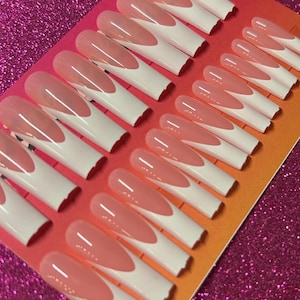 May include: A set of 20 pink and white false nails with a French tip design. The nails are arranged in rows on a pink and orange background.