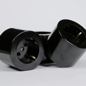 Peut inclure: Trois adaptateurs de prise électrique en bakélite noire. Les adaptateurs ont trois trous ronds et une seule broche ronde.