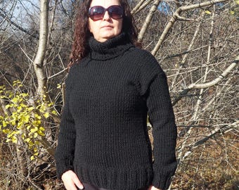 May include: A black turtleneck sweater with long sleeves. The sweater is knitted with a thick yarn and has a relaxed fit.