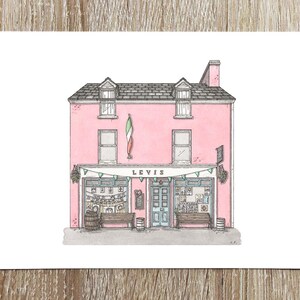 Peut inclure: Illustration à l'aquarelle d'un bâtiment rose avec le mot "LEVIS" au-dessus de l'entrée. Le bâtiment a un toit gris, deux fenêtres et un drapeau vert, blanc et orange. Des bancs et des barils sont devant le bâtiment.