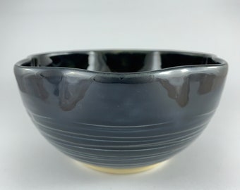 Altered rim ceramic bowl with a black / olive glaze and a carved line detail outside. 14cm