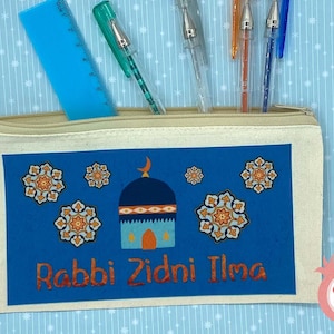 Op de afbeelding: Een beige canvas potlood etui met een rits. De voorkant van het etui heeft een blauwe achtergrond met een moskee ontwerp en de tekst "Rabbi Zidni Ilma" in rood. Het moskee ontwerp bevat een halve maan, een koepel en een raam met twee ogen.